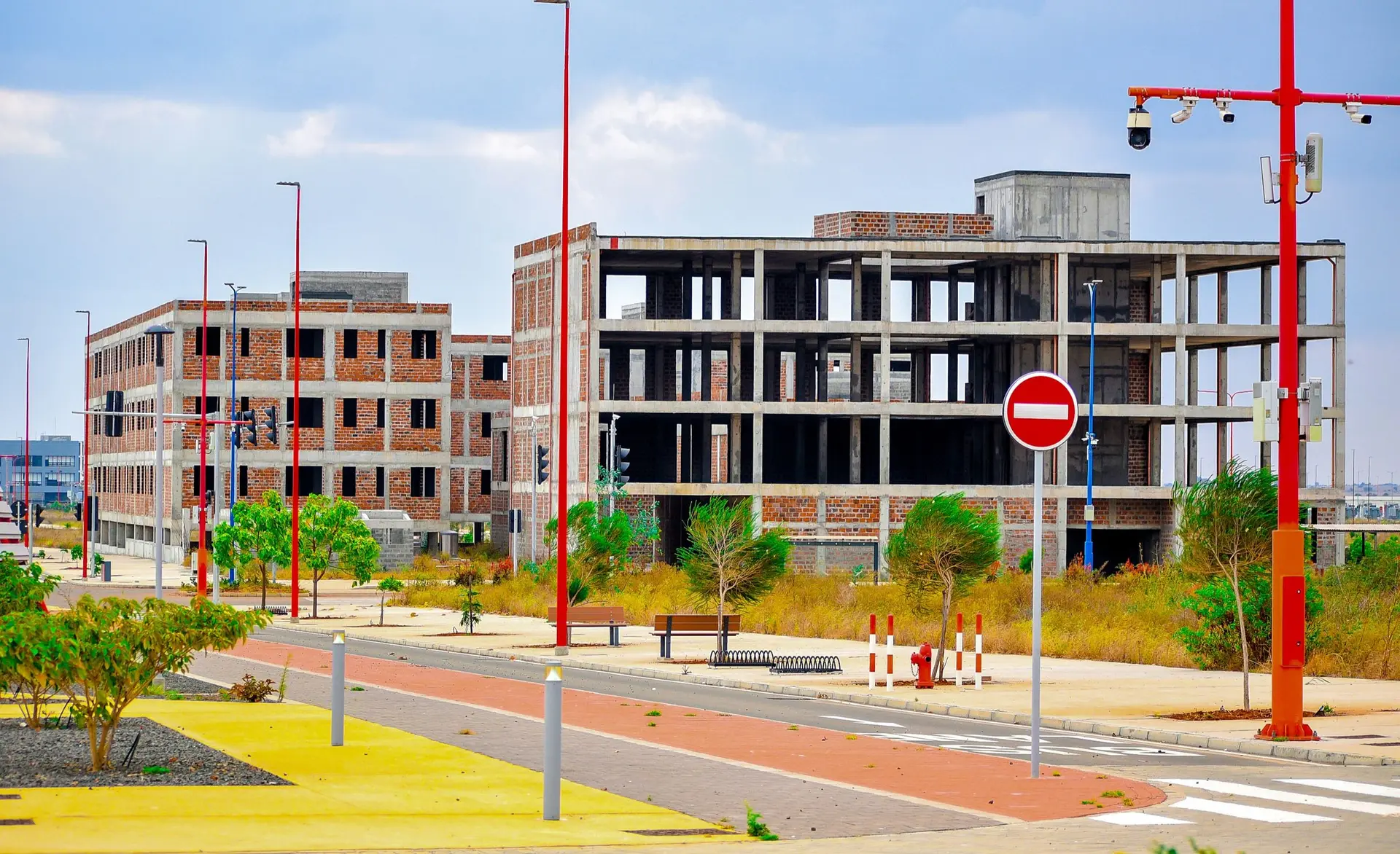 Concrete frame of a mid-rise building beside a new street