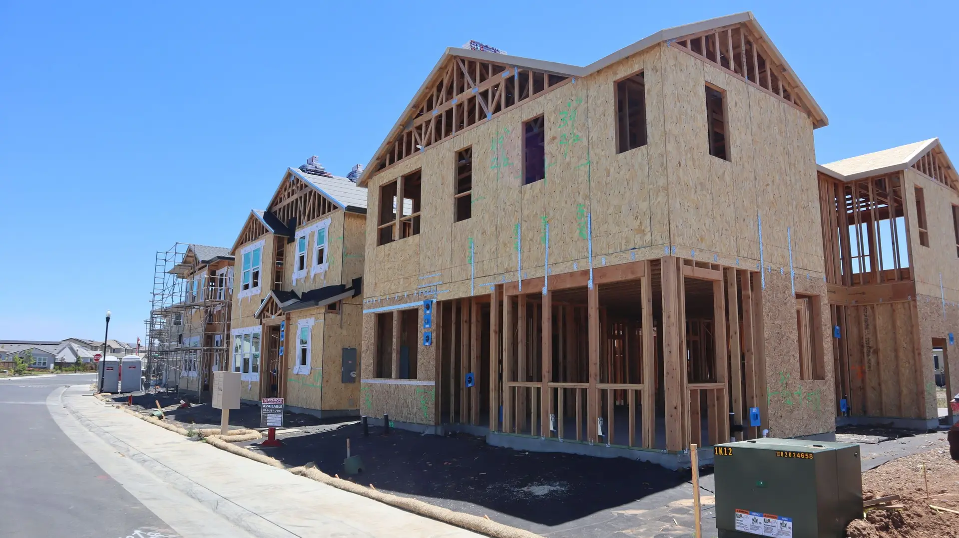 Two-story wood frame houses sheathed and roofed on a new street
