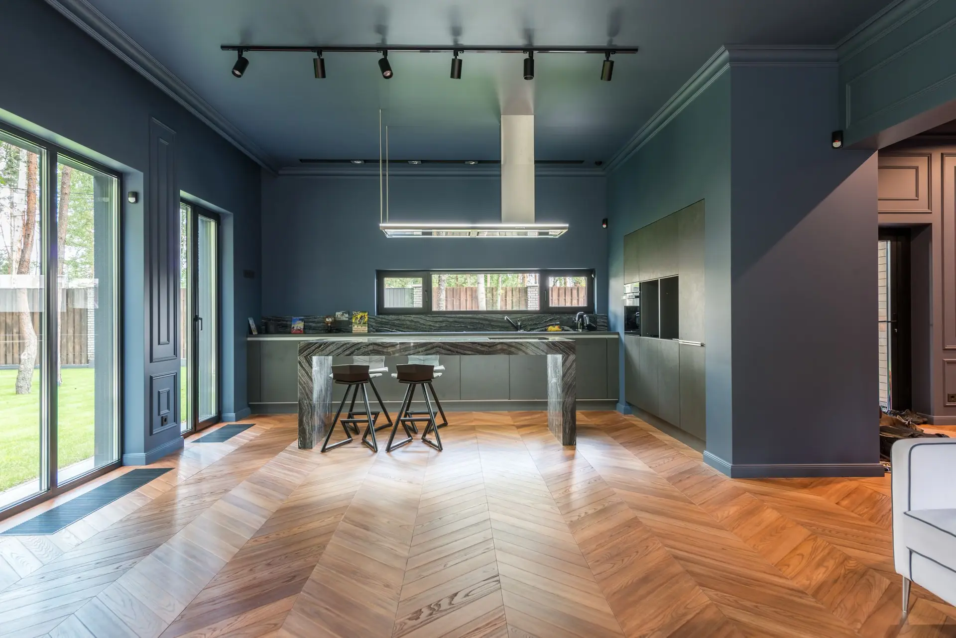 Open kitchen with a chevron parquet floor and dark walls