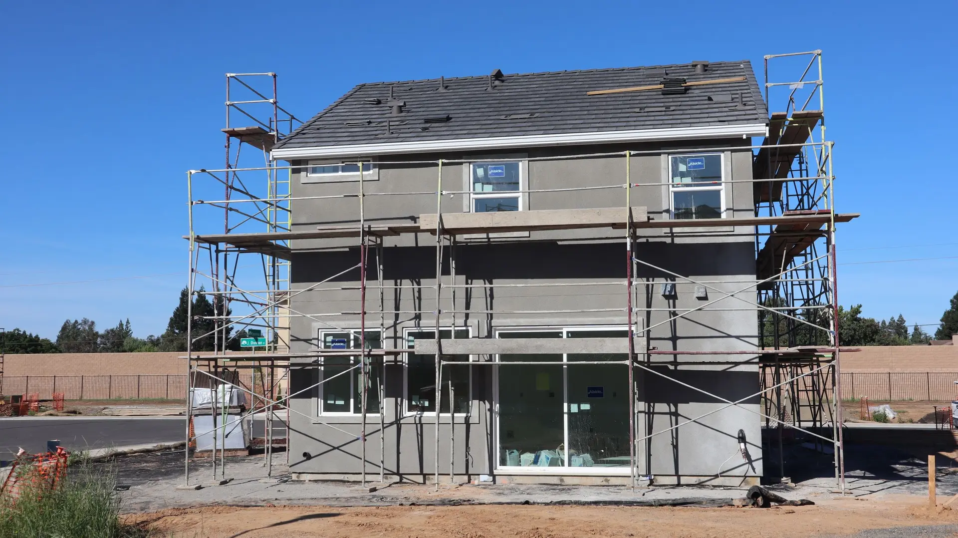 Gray two-story house surrounded by scaffolding